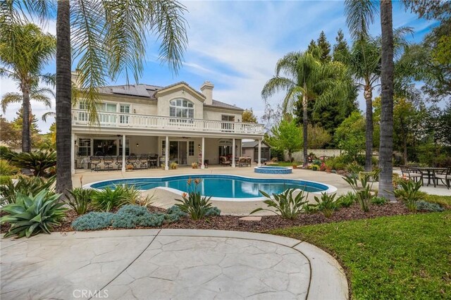 outdoor pool featuring a patio and an in ground hot tub