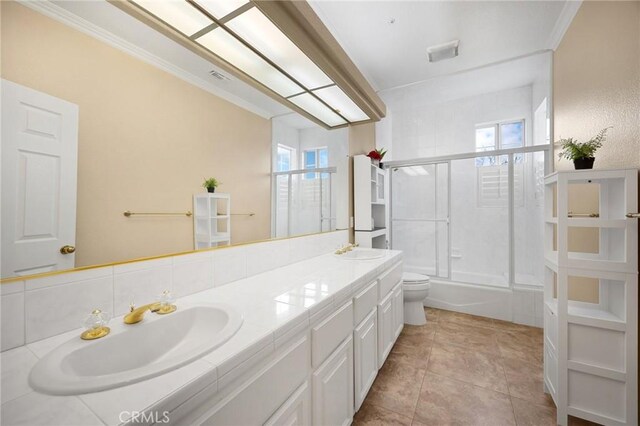 full bath featuring a sink, plenty of natural light, toilet, and double vanity