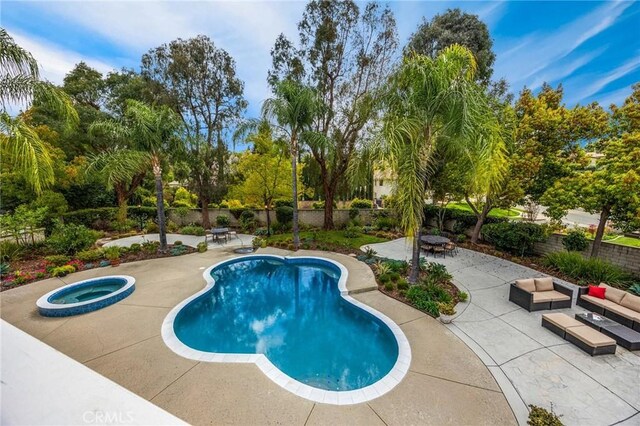 view of pool with fence, a fenced in pool, an in ground hot tub, and a patio area