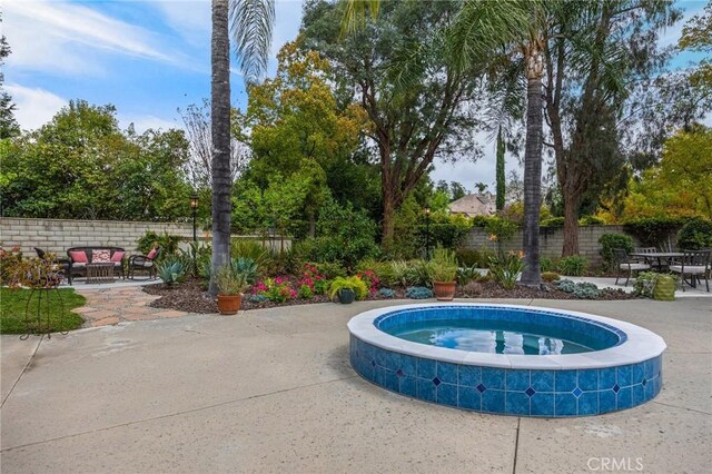 view of pool with fence, an in ground hot tub, a patio area, and outdoor lounge area