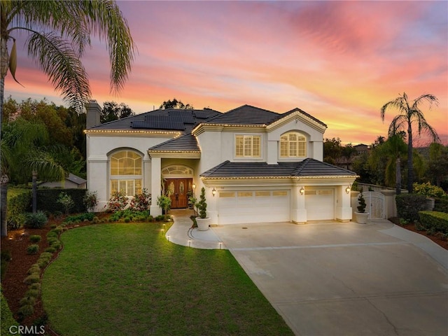 view of front of home featuring a garage, stucco siding, concrete driveway, french doors, and a yard