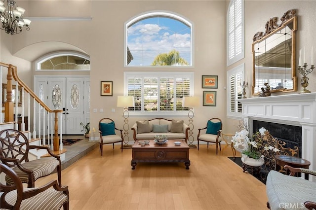 748 E Mariposa Dr, Redlands, CA 92373 - living room featuring a high ceiling, wood finished floors, a chandelier, stairway, and plenty of natural light
