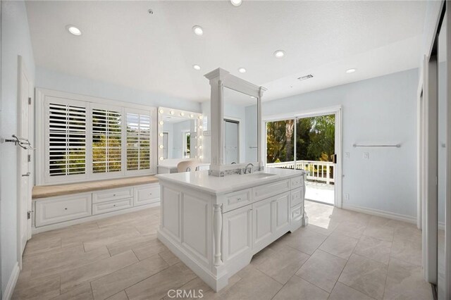 kitchen featuring visible vents, a sink, light countertops, white cabinets, and recessed lighting