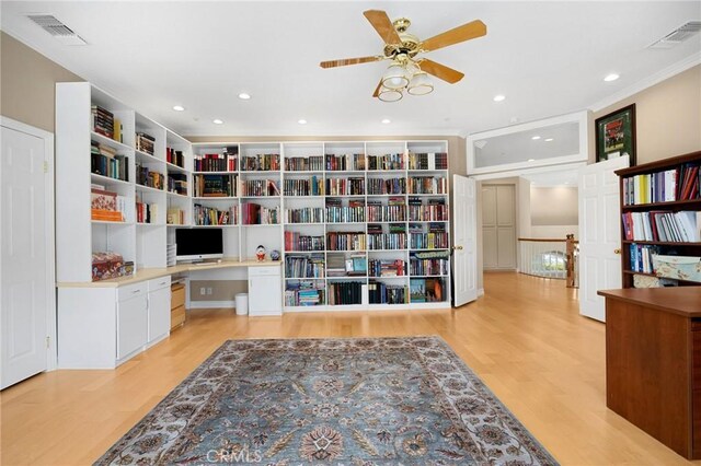 sitting room featuring visible vents, built in study area, and light wood-type flooring