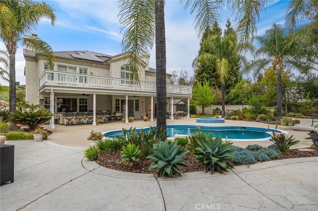 outdoor pool featuring a patio and an in ground hot tub