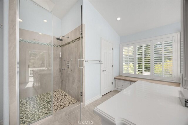 full bathroom featuring baseboards, recessed lighting, vaulted ceiling, and a shower stall