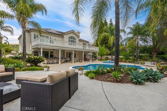 outdoor pool with a patio area and an outdoor hangout area