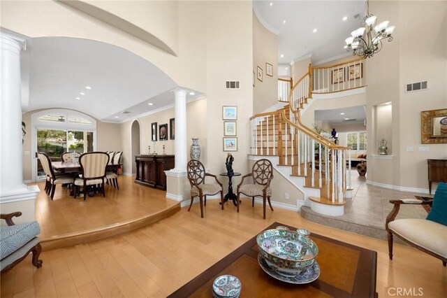 interior space with ornate columns, arched walkways, wood finished floors, and visible vents