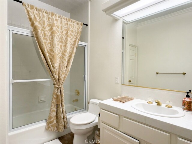 bathroom featuring crown molding, vanity, combined bath / shower with glass door, and toilet