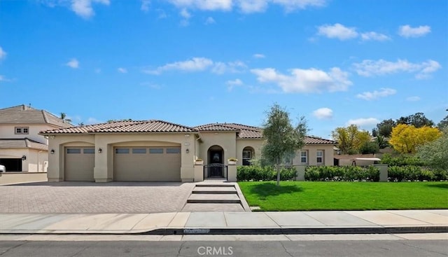 12149 Jonathan Dr, Riverside, CA 92503 - mediterranean / spanish-style home featuring a tiled roof, an attached garage, stucco siding, a front yard, and decorative driveway