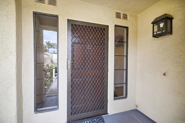 3116 Vista Bonita, Carlsbad, CA 92009 - doorway to property with visible vents and stucco siding
