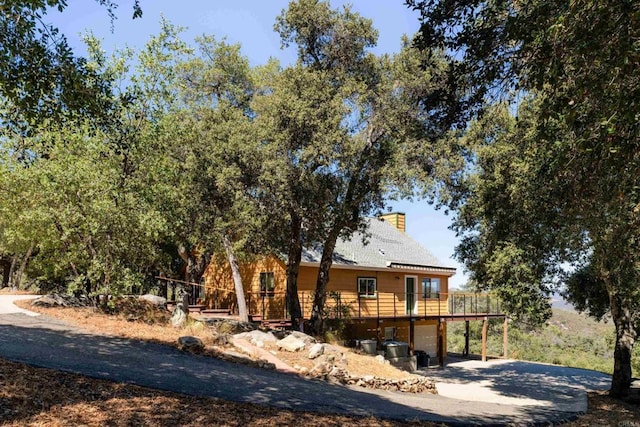 25770 E Grade Rd, Santa Ysabel, CA 92070 - view of front of home featuring driveway, a wooden deck, a chimney, and a garage