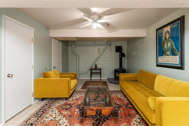 25770 E Grade Rd, Santa Ysabel, CA 92070 - living room featuring a wood stove, concrete block wall, ceiling fan, and light tile patterned floors
