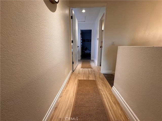 1497 Chaparral Way, Oceanside, CA 92057 - corridor with a textured wall, light wood-style flooring, attic access, and baseboards