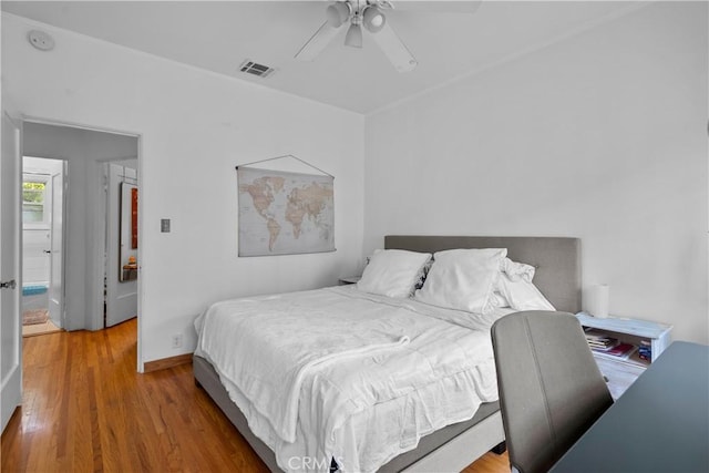 bedroom featuring baseboards, visible vents, wood finished floors, and ceiling fan