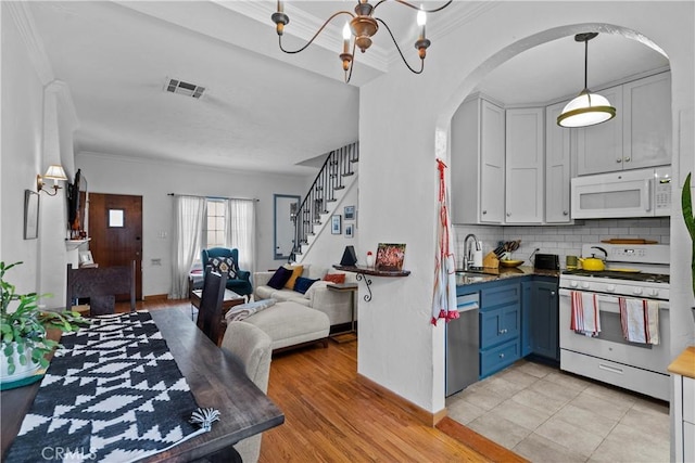 kitchen with decorative backsplash, visible vents, white appliances, arched walkways, and open floor plan