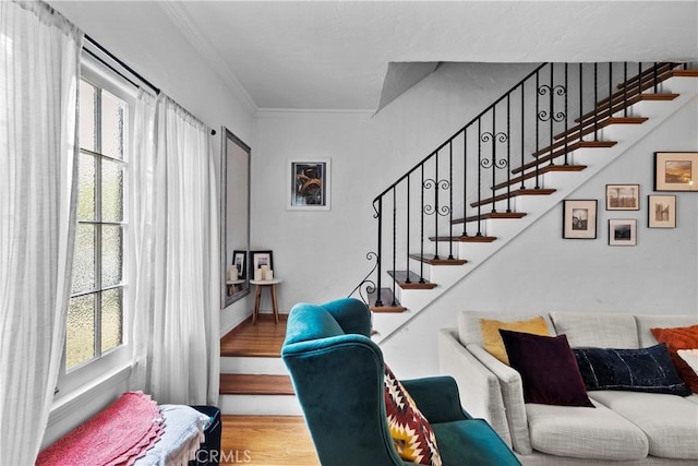 stairway with crown molding and wood finished floors