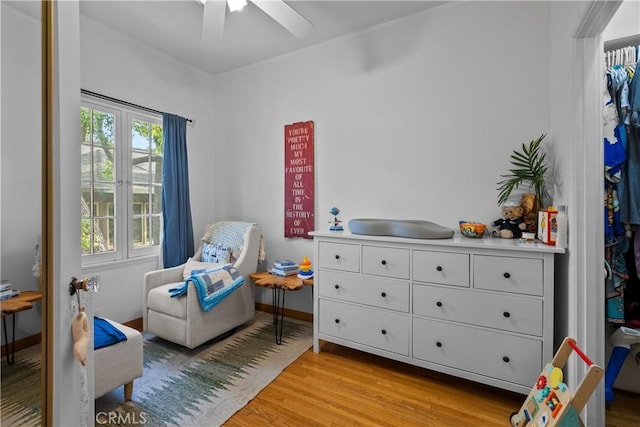interior space featuring baseboards, a ceiling fan, and light wood-type flooring
