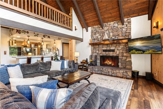 675 Grass Valley Rd, Lake Arrowhead, CA 92352 - living room featuring a stone fireplace, wooden ceiling, baseboards, beamed ceiling, and wood-type flooring
