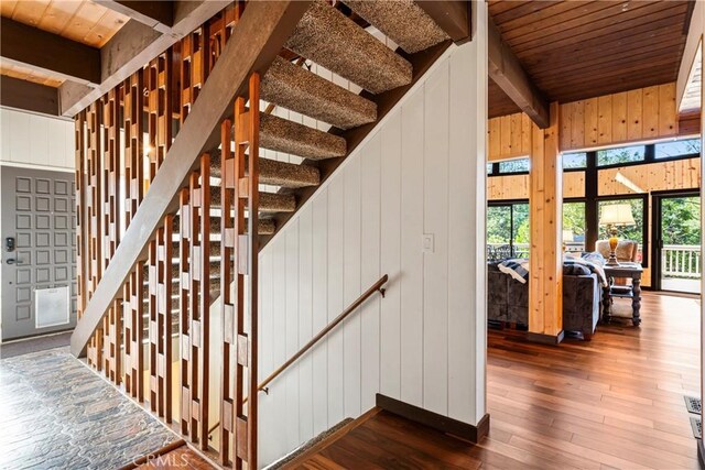 675 Grass Valley Rd, Lake Arrowhead, CA 92352 - stairs featuring beamed ceiling, wood walls, wood ceiling, and hardwood / wood-style floors