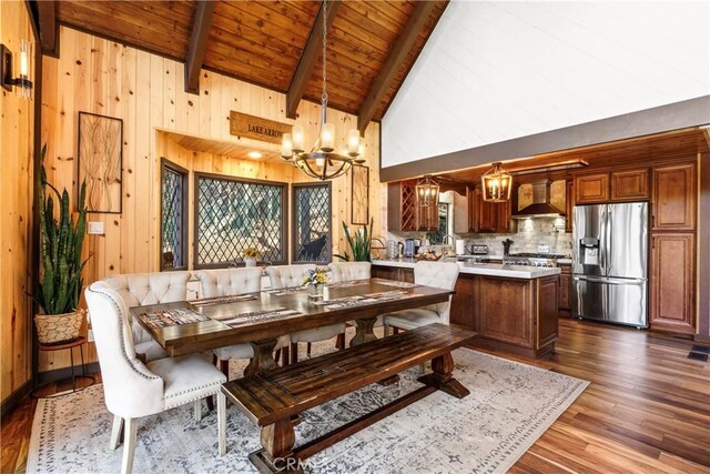 675 Grass Valley Rd, Lake Arrowhead, CA 92352 - dining space featuring an inviting chandelier, beamed ceiling, wooden walls, wood ceiling, and dark wood finished floors
