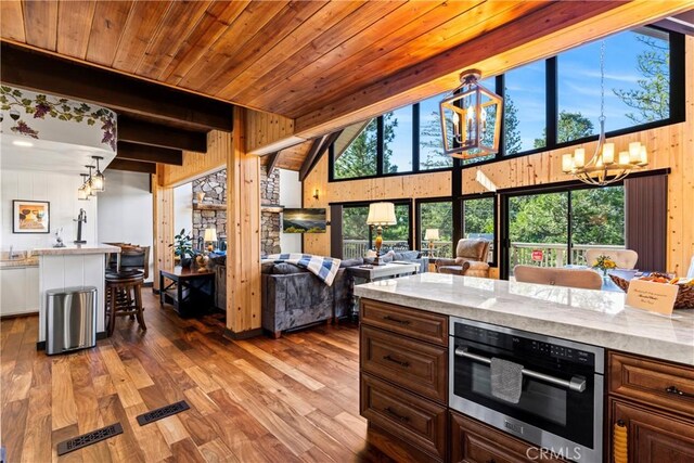 675 Grass Valley Rd, Lake Arrowhead, CA 92352 - kitchen with stainless steel oven, open floor plan, wood finished floors, and a notable chandelier
