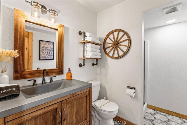 675 Grass Valley Rd, Lake Arrowhead, CA 92352 - bathroom featuring toilet, baseboards, visible vents, and vanity