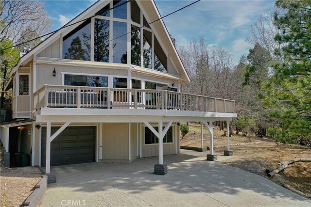 675 Grass Valley Rd, Lake Arrowhead, CA 92352 - view of front of house with a garage, concrete driveway, and a deck