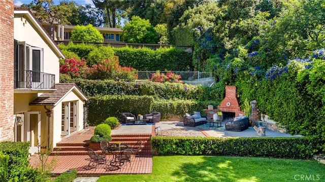 view of yard featuring a patio area, fence, and an outdoor brick fireplace