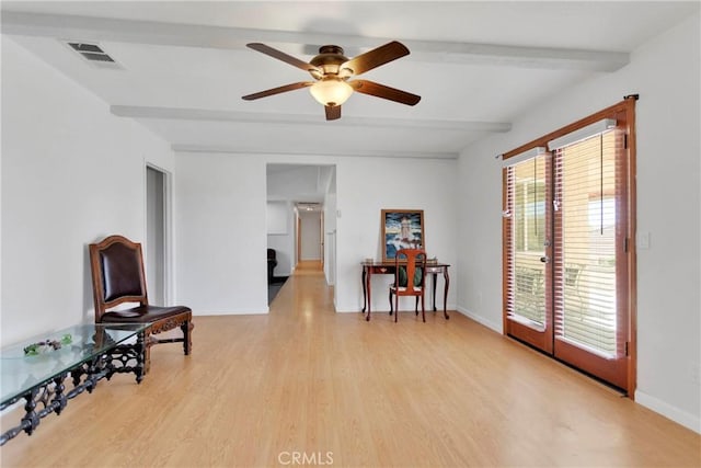 sitting room featuring visible vents, baseboards, ceiling fan, beam ceiling, and light wood-type flooring