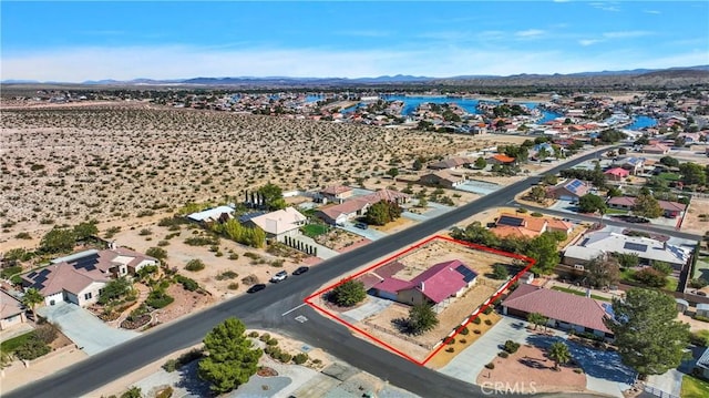 drone / aerial view featuring a water and mountain view and a desert view