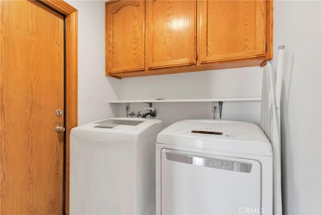 washroom featuring cabinet space and washer and dryer