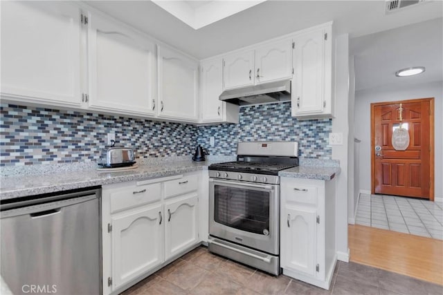 kitchen with white cabinets, stainless steel appliances, under cabinet range hood, and visible vents
