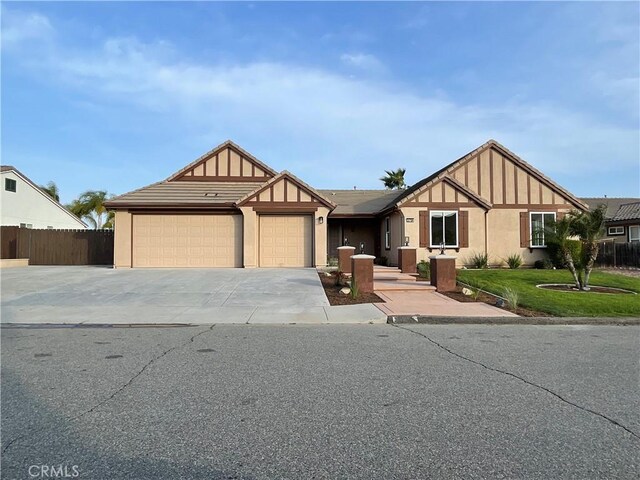 32706 Blue Mist Way, Wildomar, CA 92595 - english style home with fence, a front lawn, stucco siding, an attached garage, and driveway