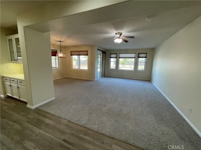32706 Blue Mist Way, Wildomar, CA 92595 - unfurnished living room featuring ceiling fan with notable chandelier, plenty of natural light, and baseboards