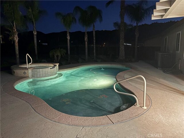 32706 Blue Mist Way, Wildomar, CA 92595 - pool at twilight featuring central AC, a patio area, and a pool with connected hot tub