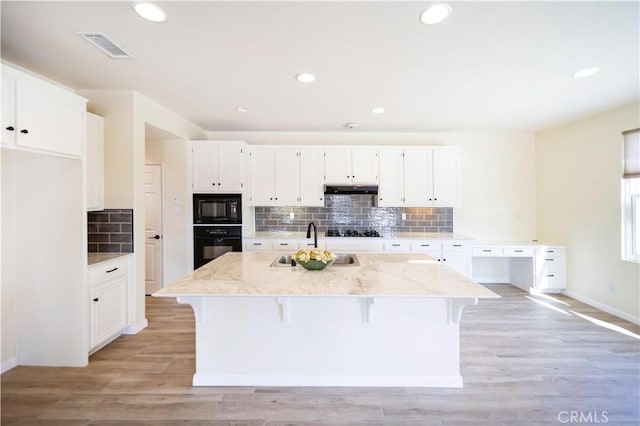 32706 Blue Mist Way, Wildomar, CA 92595 - kitchen with white cabinets, light stone counters, a sink, and black appliances