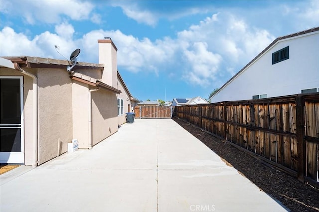 32706 Blue Mist Way, Wildomar, CA 92595 - view of home's exterior with a fenced backyard, a patio, stucco siding, and a chimney