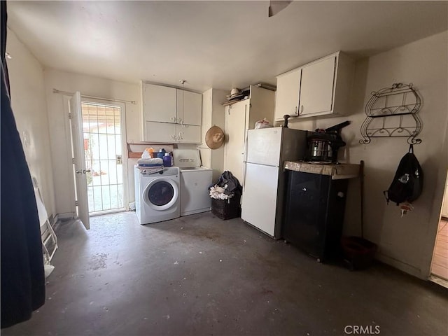 105 Orange Ave, Chowchilla, CA 93610 - interior space featuring washing machine and clothes dryer, freestanding refrigerator, unfinished concrete flooring, and white cabinetry