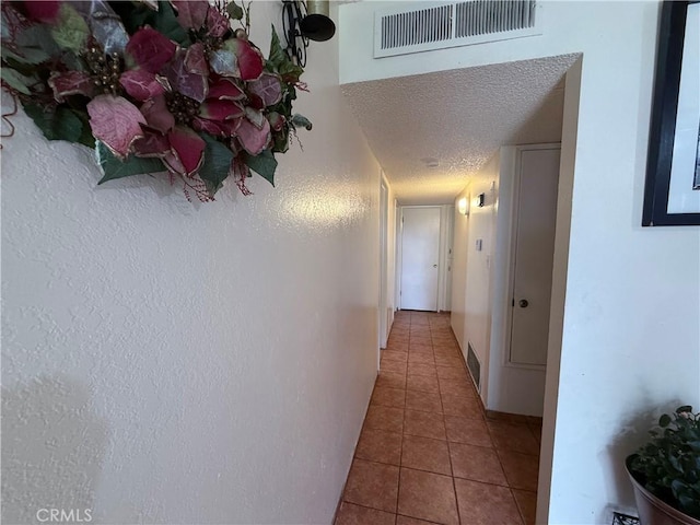 105 Orange Ave, Chowchilla, CA 93610 - corridor with visible vents, a textured ceiling, and tile patterned flooring