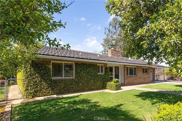 ranch-style house featuring fence, a gate, a front lawn, brick siding, and a chimney