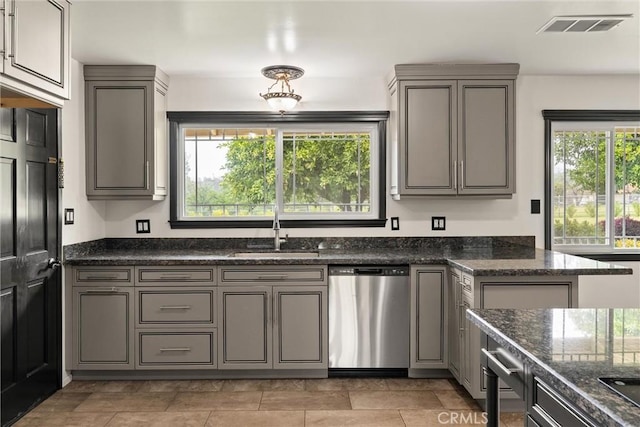 kitchen featuring dishwasher, gray cabinets, a sink, and visible vents