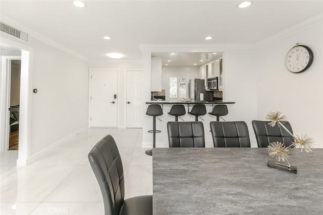 dining area with visible vents, crown molding, baseboards, recessed lighting, and light tile patterned floors