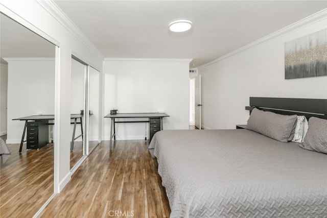 bedroom featuring baseboards, visible vents, ornamental molding, and wood finished floors