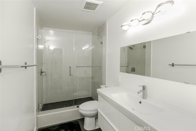bathroom with vanity, visible vents, toilet, and a shower stall