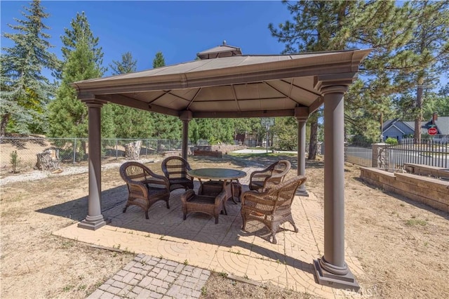 view of patio / terrace featuring a gazebo, outdoor dining area, and a fenced backyard