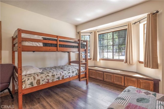 bedroom with dark wood-style floors and visible vents