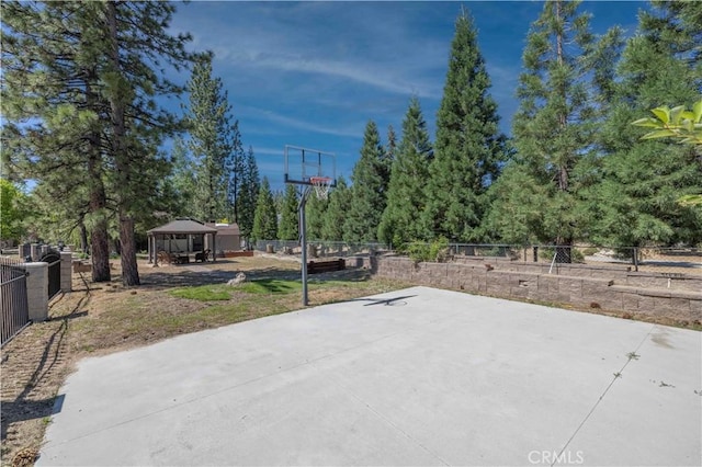 view of patio / terrace featuring a gazebo, fence, and basketball court