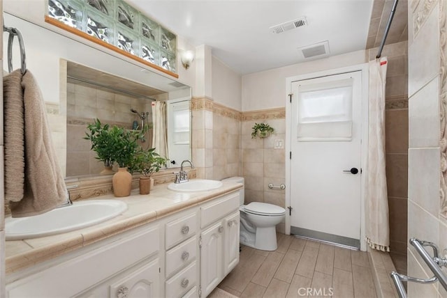 9871 Silver Strand Dr, Huntington Beach, CA 92646 - full bath featuring tile walls, visible vents, toilet, and a sink