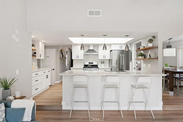 9871 Silver Strand Dr, Huntington Beach, CA 92646 - kitchen with open shelves, light wood finished floors, appliances with stainless steel finishes, wall chimney range hood, and visible vents